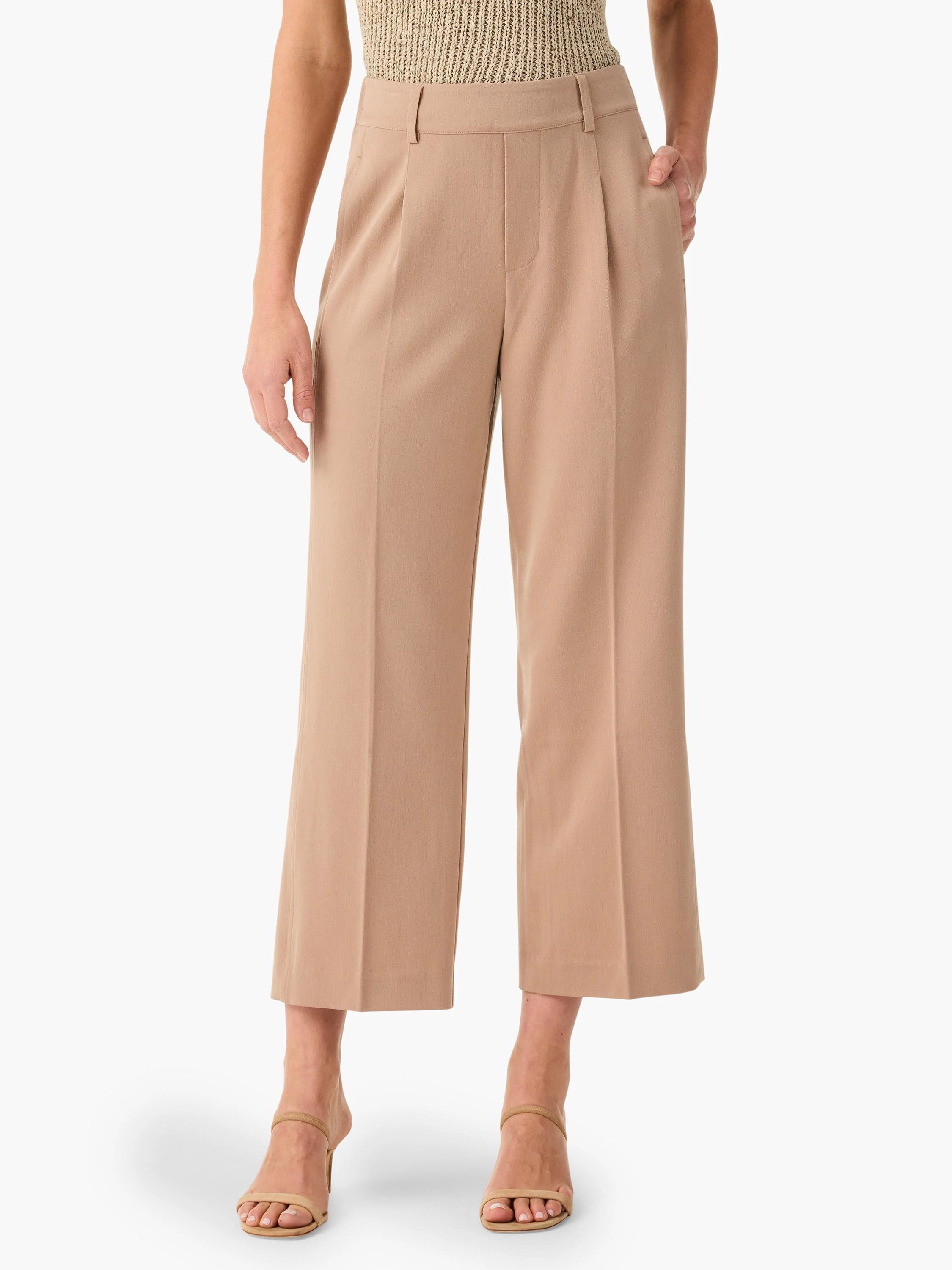 Beige wide-leg cropped trousers with center pleats;  model wears light beige shoes.