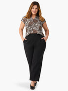 Black, wide-leg cropped trousers on a model.  High-waisted with pleats.