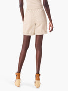 Beige poplin shorts; cuffed hems, back pockets, elastic waistband.  Model wears tan wedges.