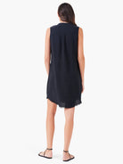 Black sleeveless linen dress, hem with frayed edges.  Model shown from behind.