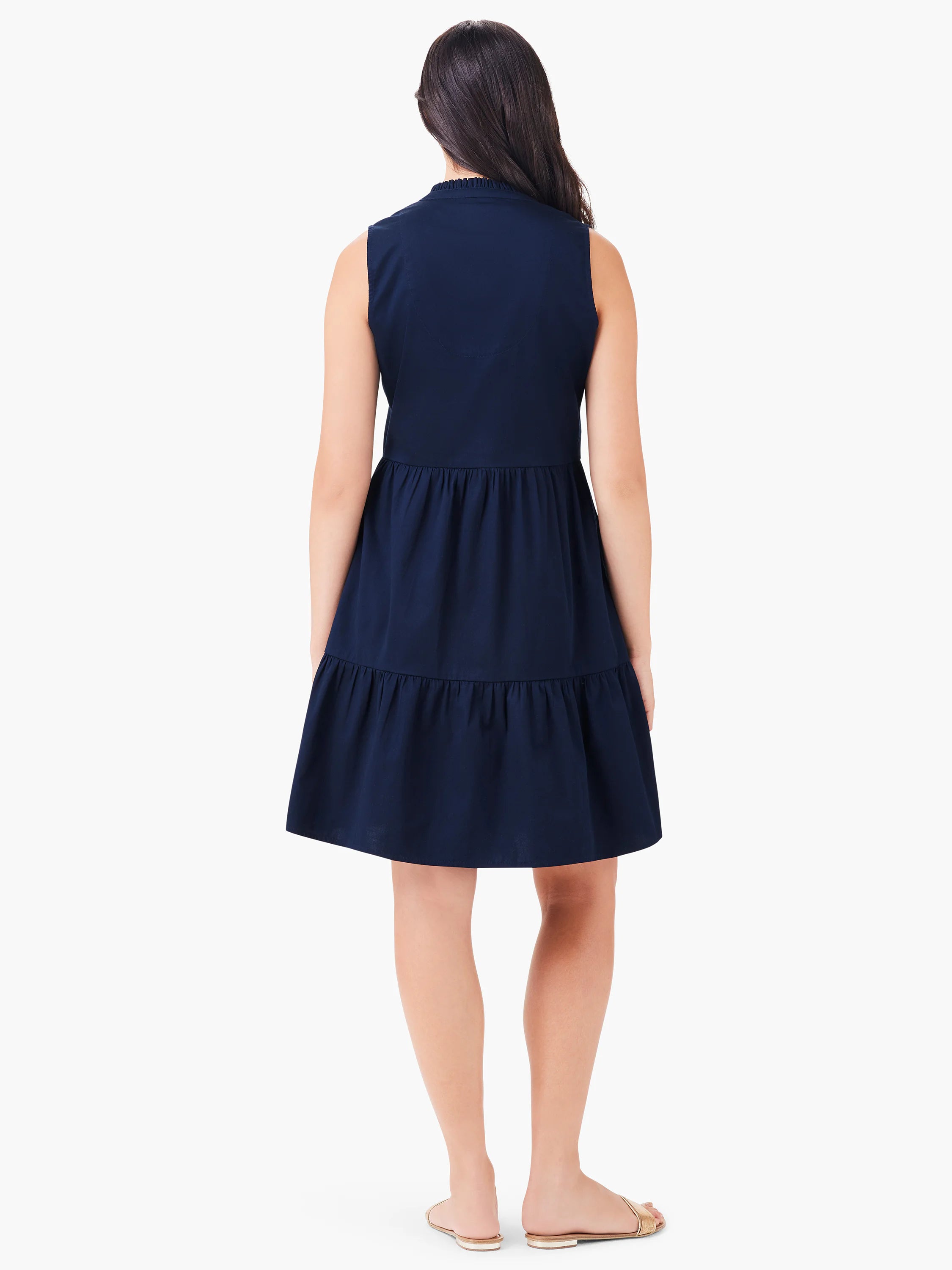 Navy blue sleeveless tiered dress, shown from the back.  The dress has a slightly gathered waist and a small ruffle at...