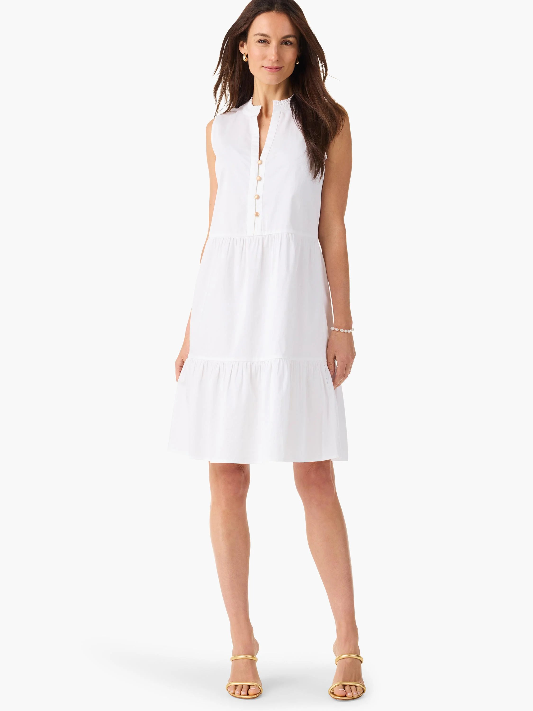 White sleeveless tiered dress with a button placket and gold buttons.