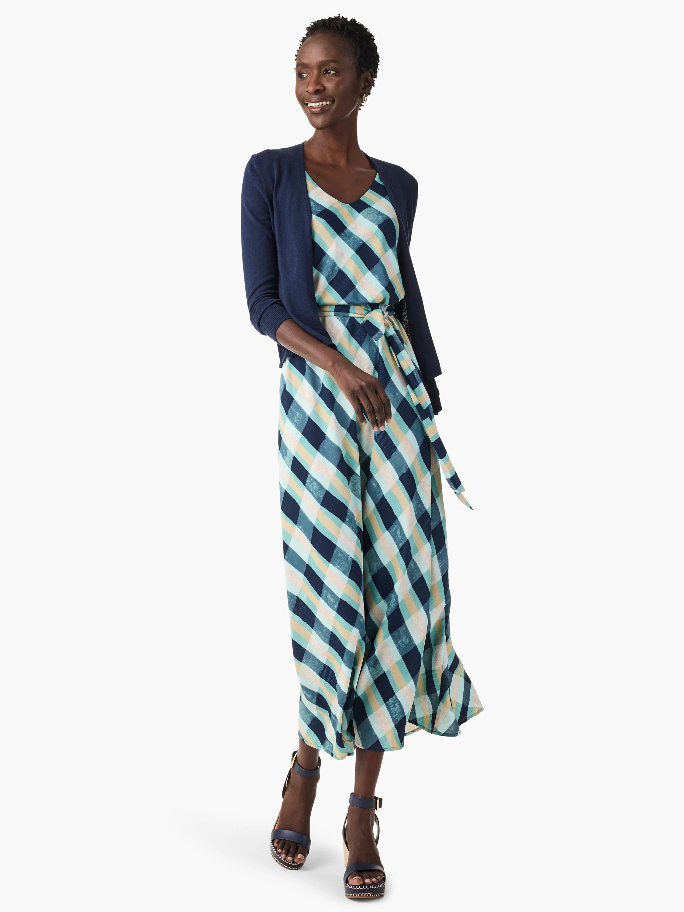 Maxi dress with a teal, navy, and beige plaid pattern.  The dress has a V-neck and a self-tie belt.  Model is wearing a...