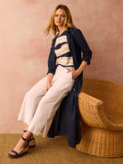 Navy blue tunic; long sleeves, knee-length.  Model wears it over a beige and navy striped shirt.