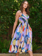 Midi dress, sleeveless, V-neck.  Abstract print featuring blues, purples, oranges, yellows, and pinks in a geometric pattern.