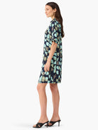 Side view of short navy dress with teal and gray abstract print.  Short sleeves.