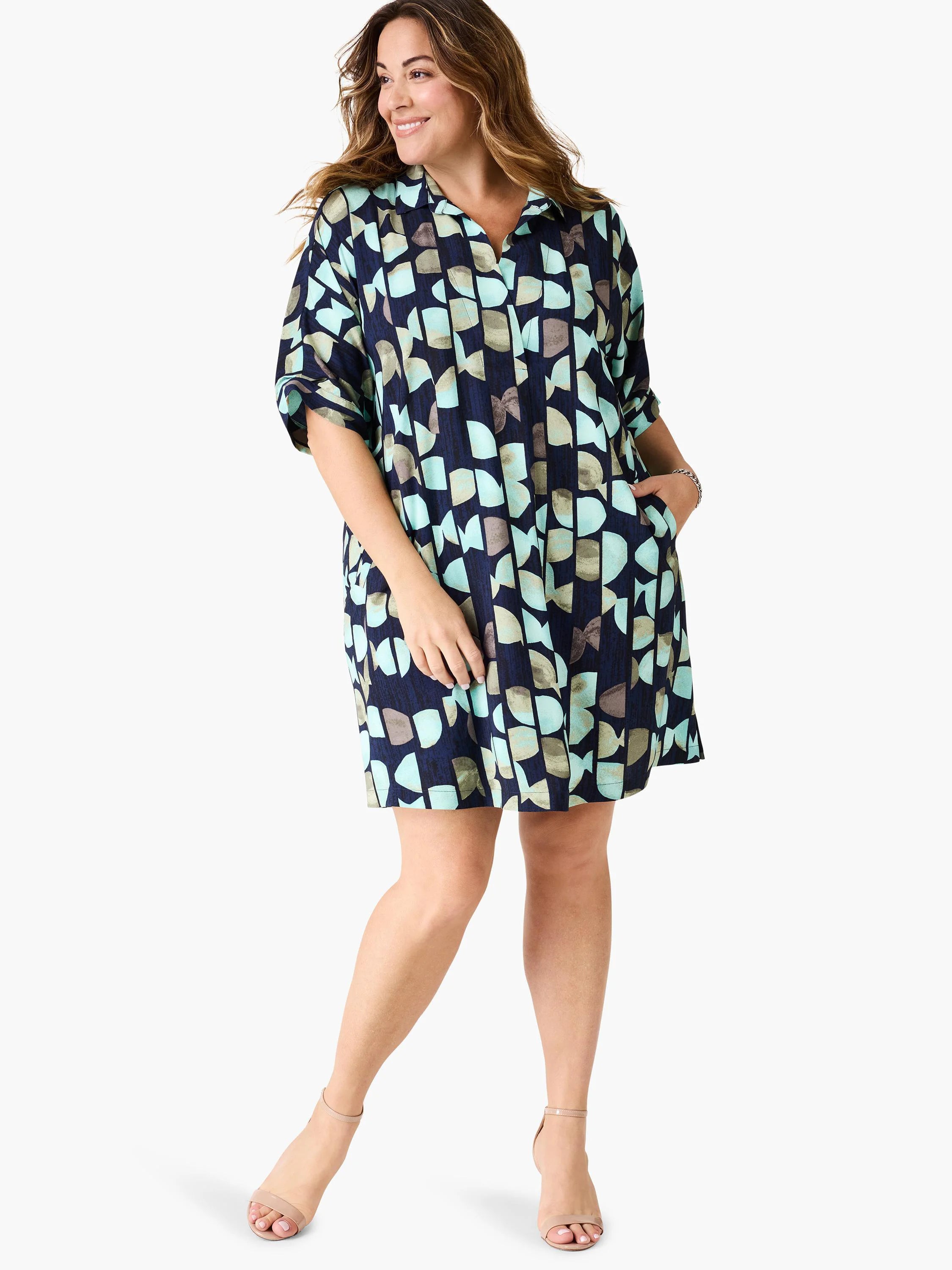 Navy blue dress with teal, green, and gray abstract print. Short sleeves, collared neckline, and pockets. Knee-length.