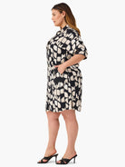 Black shirt dress with beige abstract print, short sleeves, and pockets.  Knee-length.