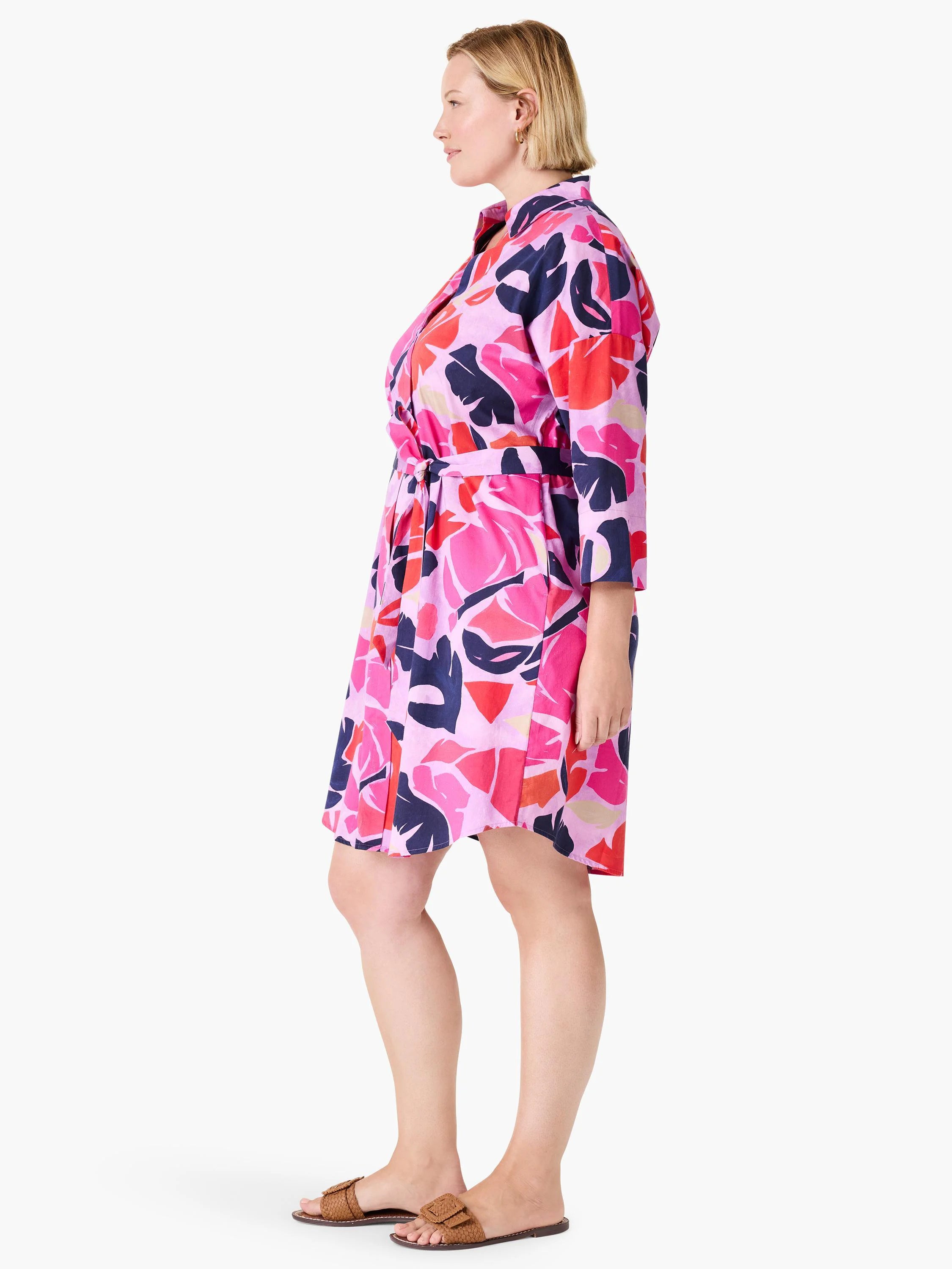 Pink shirt dress with a belted waist.  Features a red, pink, and navy abstract leaf print.  Three-quarter sleeves.
