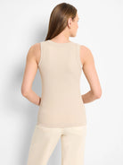 Back view of a woman wearing a beige ribbed knit scoop tank top.