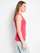 Bright pink ribbed knit scoop tank top, shown on a model from the side.