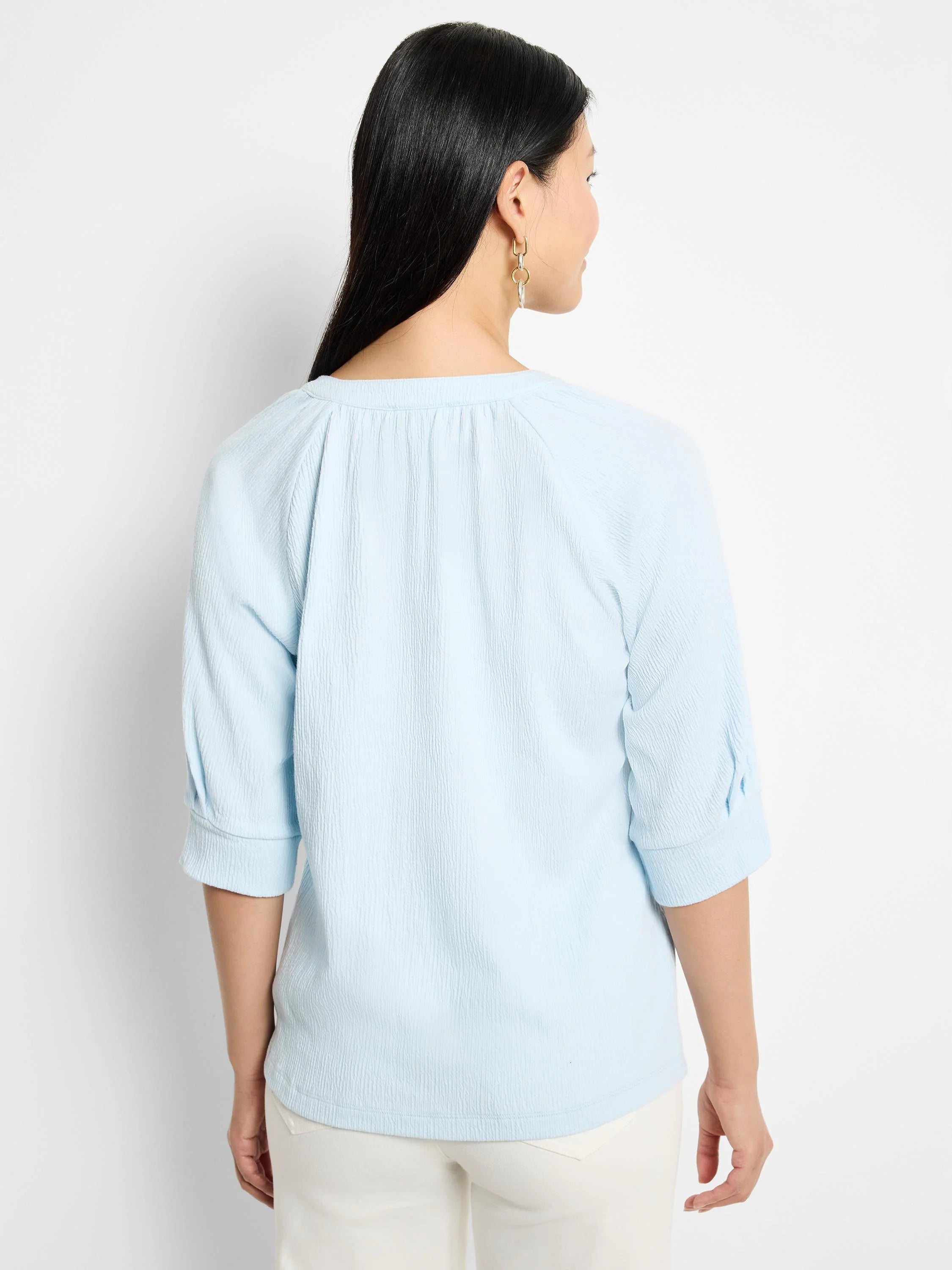 Light blue, textured knit top.  Three-quarter sleeves, round neckline.  Back view.