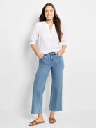 White, textured knit top with V-neck and three-quarter sleeves.