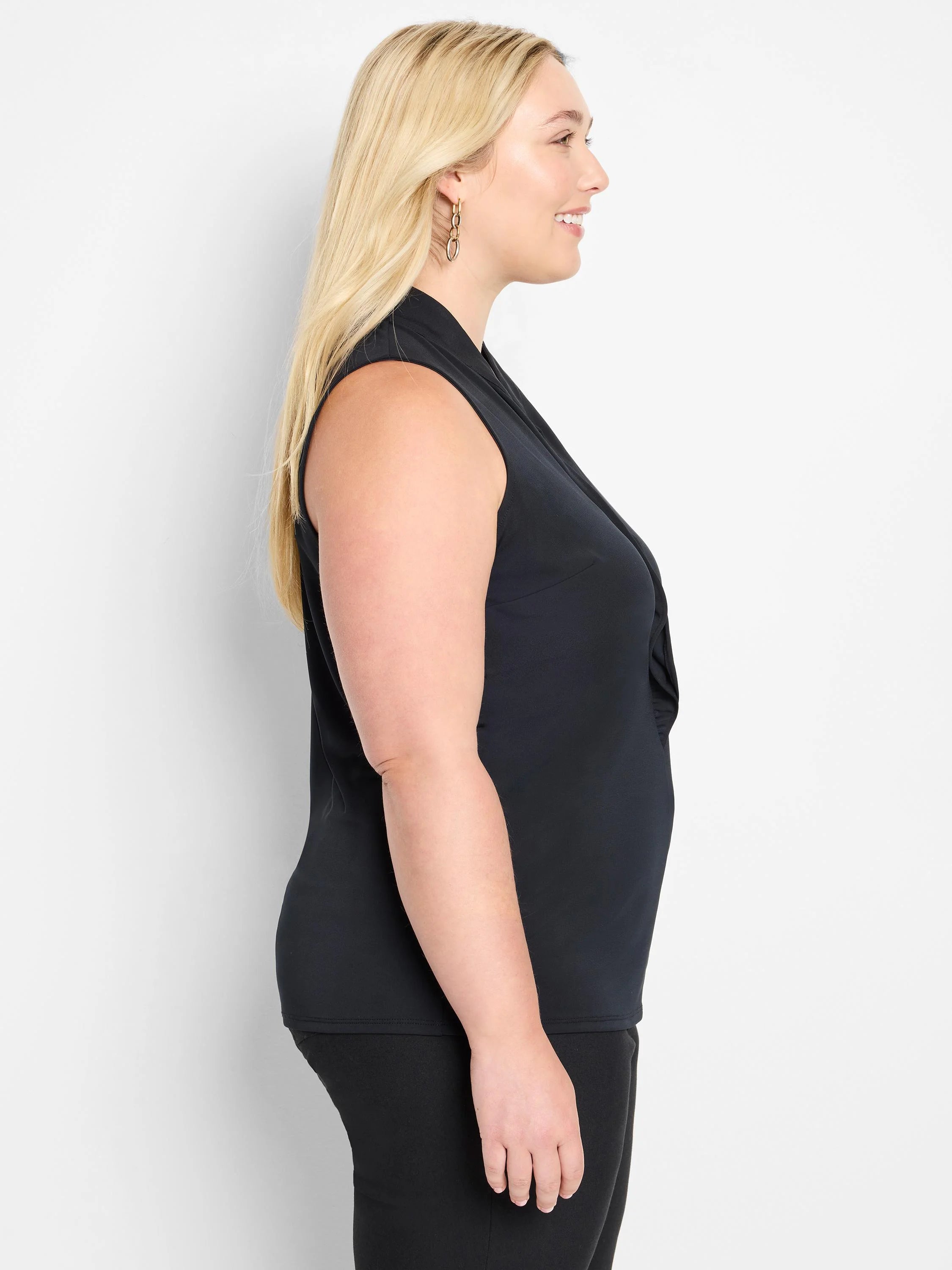 Black sleeveless knit top with a cowl neck and ruffles at the neckline.