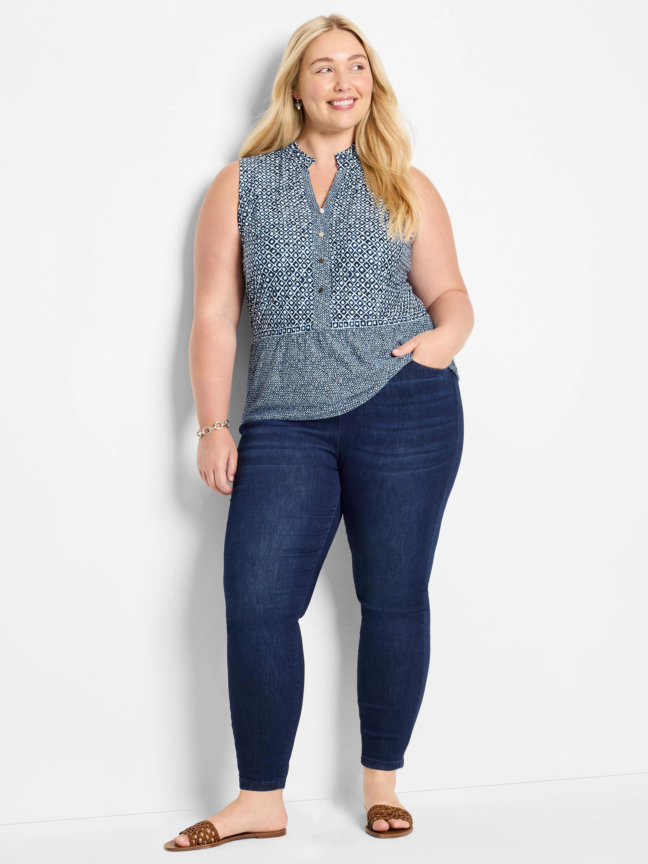 Sleeveless blue knit top with white geometric pattern,  button placket.