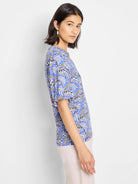 Blue top with short sleeves, featuring a beige and black geometric print.