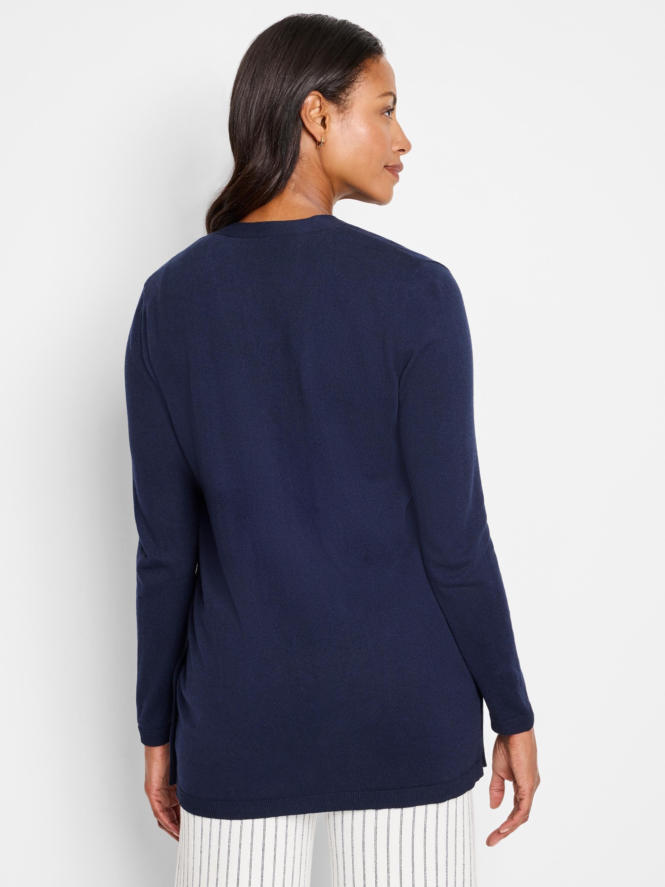 Navy blue, long-sleeved cardigan;  straight hem,  ribbed texture.  Shown from the back.