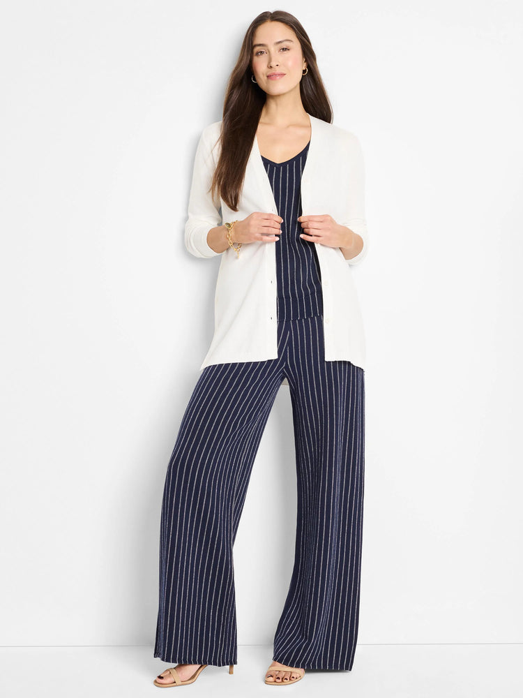 Off-white long cardigan, button front.  Model wears it over a navy pinstripe top and pants.