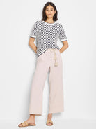 Cream-colored short-sleeve sweater with navy blue polka dot pattern.  Short sleeves and round neckline.