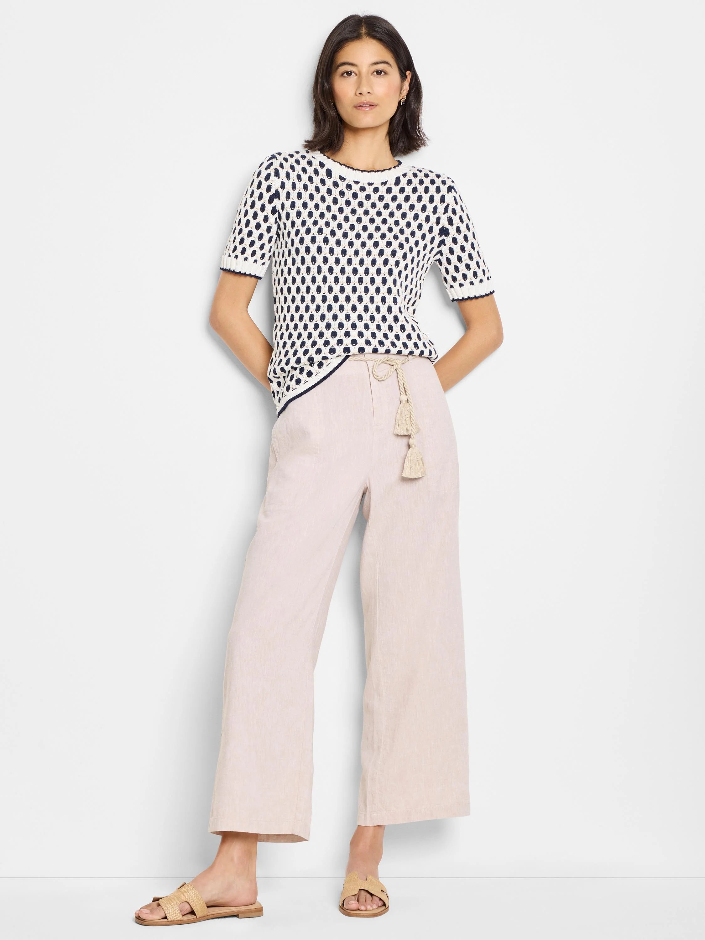 Cream-colored short-sleeve sweater with navy blue polka dot pattern.  Short sleeves and round neckline.