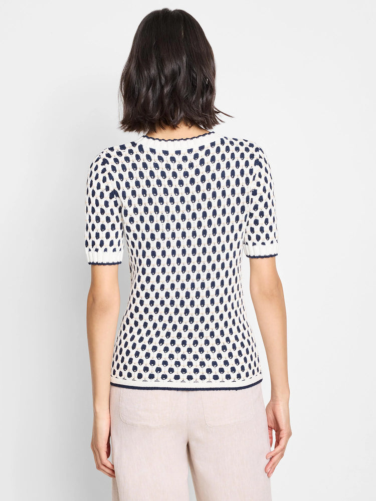 Cream-colored short-sleeve sweater with navy blue geometric pattern.  Back view.