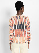 Cream, peach, and dark blue abstract pattern long-sleeve cotton sweater.