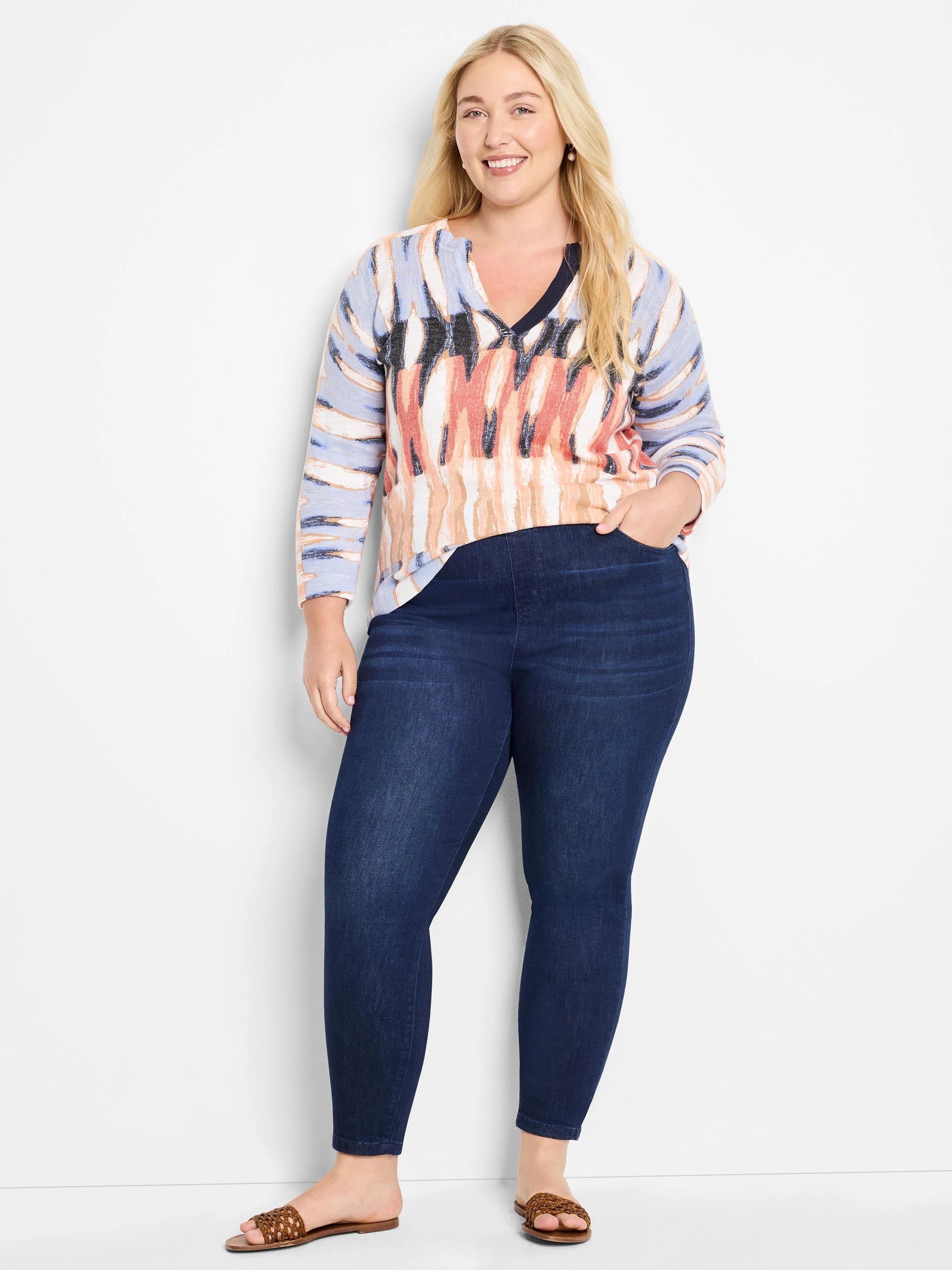 Crisscross cotton slub sweater in blue, peach, and white abstract print.  Dark wash jeans.