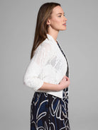 Off-white cropped cardigan with subtle sequins, open-front, three-quarter sleeves, and a lacy knit pattern.