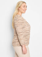 Beige knit jacket with brown and white flecks; three-quarter sleeves.