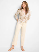 Beige v-neck sweater with a light brown floral pattern.  Long sleeves.