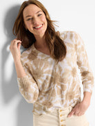 Beige sweater with a light brown floral tie-dye pattern, V-neck, long sleeves, and ribbed cuffs.