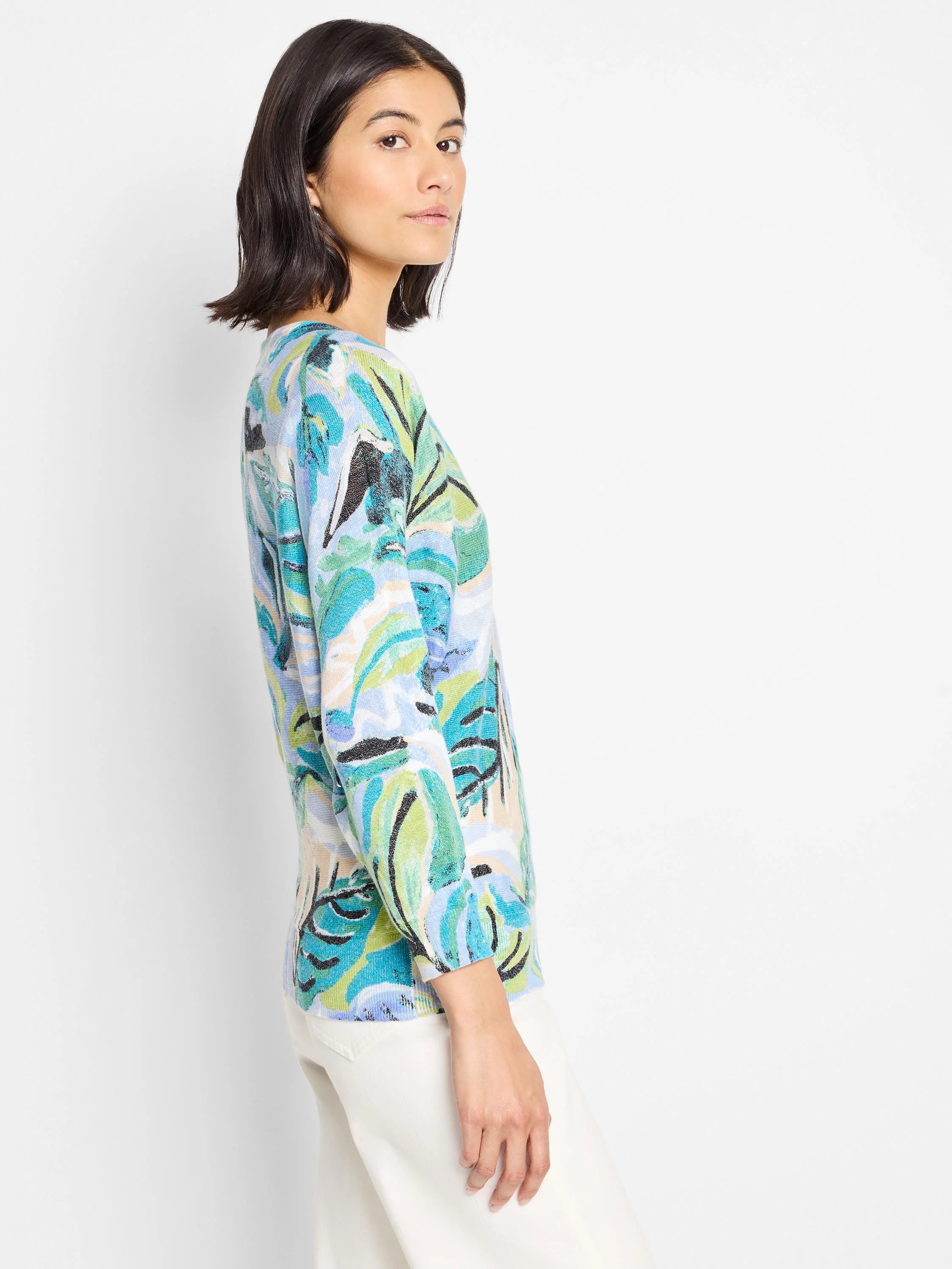 Cotton sweater, light blue base with teal, green, and black abstract leaf print. Long sleeves.
