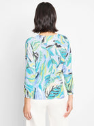 Light blue sweater with teal, green, and white leaf pattern.  Three-quarter sleeves.