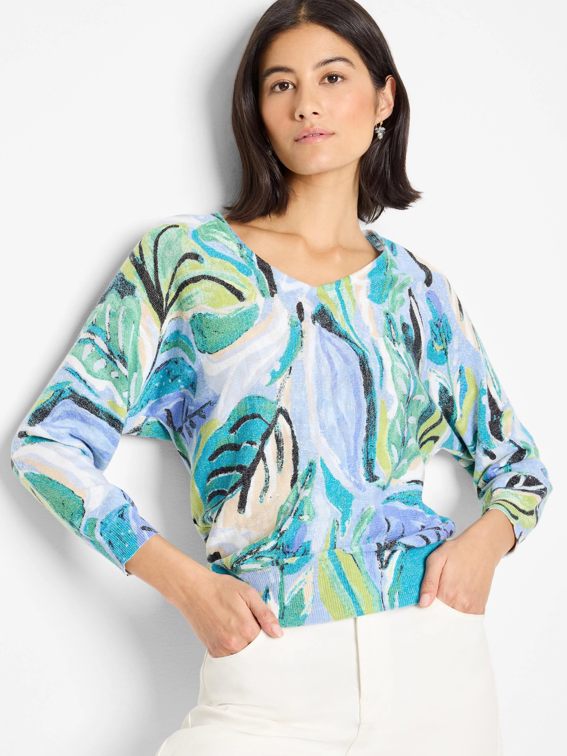 Cotton sweater with abstract leaf print in teal, light blue, green, and cream on a white background. Three-quarter...