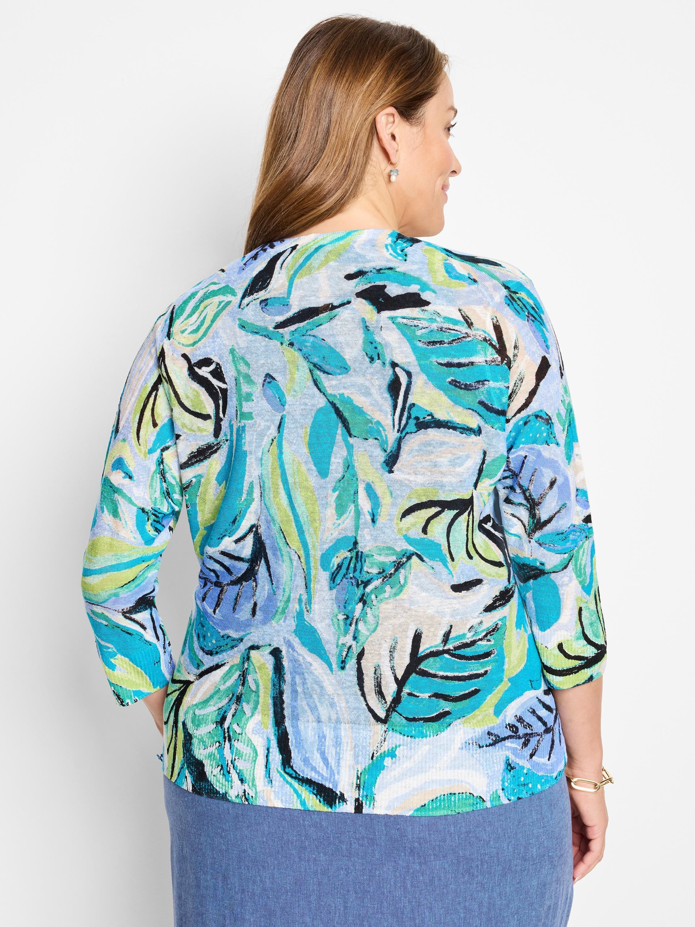 Teal, blue, green, and black leaf pattern on a light blue background. Three-quarter sleeves.