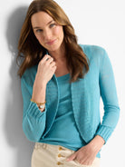 Turquoise bolero cardigan with an open front, long sleeves, and a fine knit with ribbed trim.