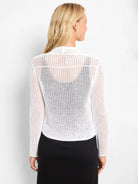 White mesh cardigan, long sleeves, open knit reveals black top, viewed from back.