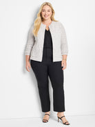 Fitted speckled gray knitted jacket featuring a collarless neckline, front zip closure, and patch pockets.