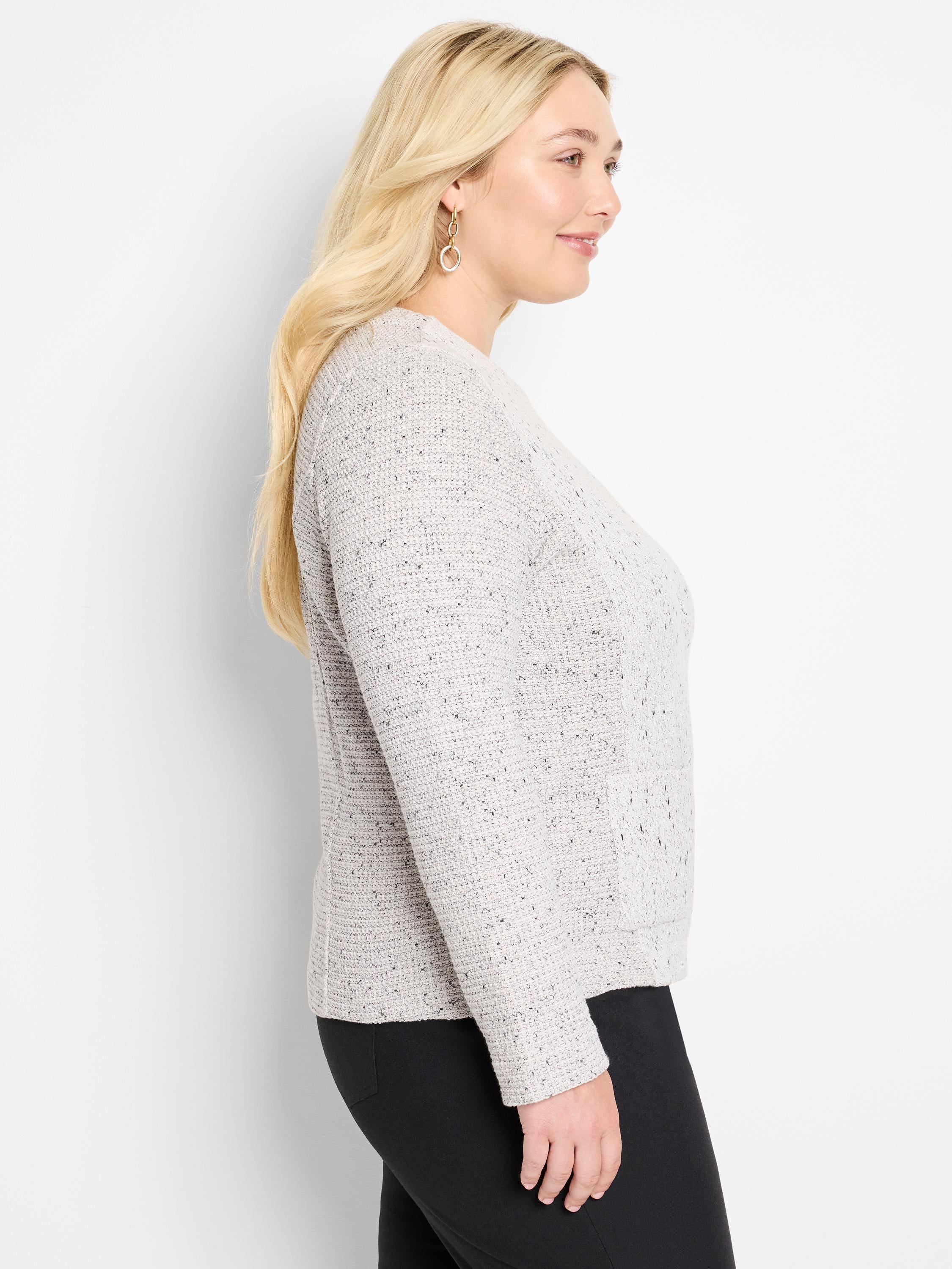 Model wears a fitted light gray speckled crew neck sweater.