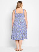 Blue midi dress with a beige, black, and white geometric pattern. Square neck, sleeveless.