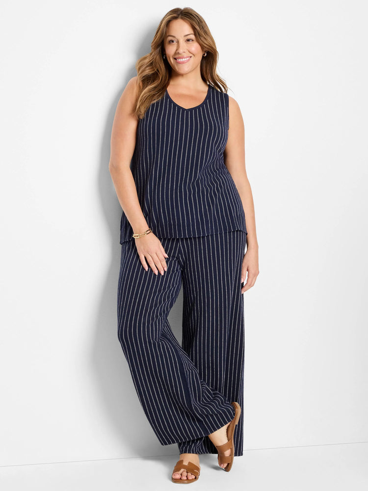 Navy blue wide-leg pants with thin white pinstripes.  A model is wearing them.