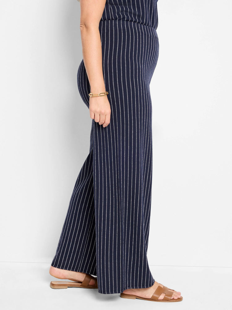 Here's alt text under 125 characters:

Navy blue wide-leg pants with thin white vertical stripes.  Knit fabric. Shown on...