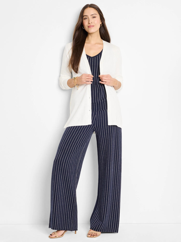 Wide-leg pants; navy blue with thin white pinstripes.  Model wears off-white cardigan.