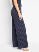 Here's alt text that meets the requirements:

Navy blue wide-leg pants with thin white pinstripes.