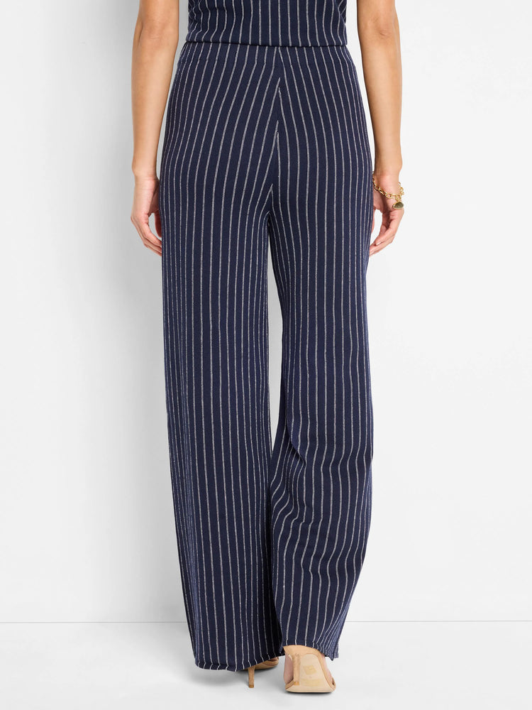 Navy blue wide-leg pants with thin white vertical stripes.  Knit fabric.