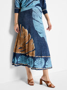Knit midi skirt in blue, light blue, and brown. Features a leaf print and a textured hemline.