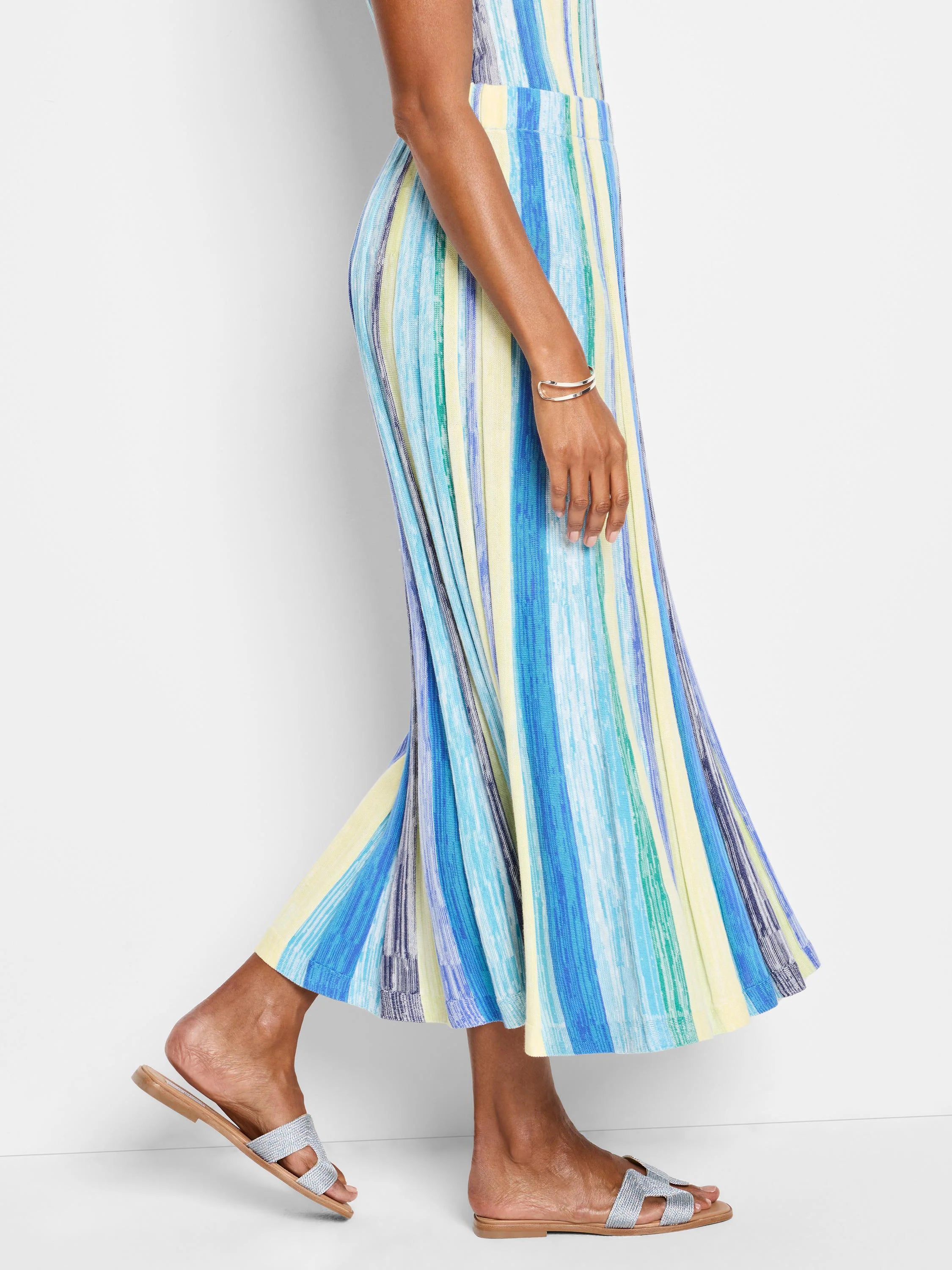 Mid-length pleated knit skirt in blue, green, and yellow vertical stripes.