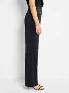 Black wide-leg pants with a black satin cummerbund.  Side profile view.