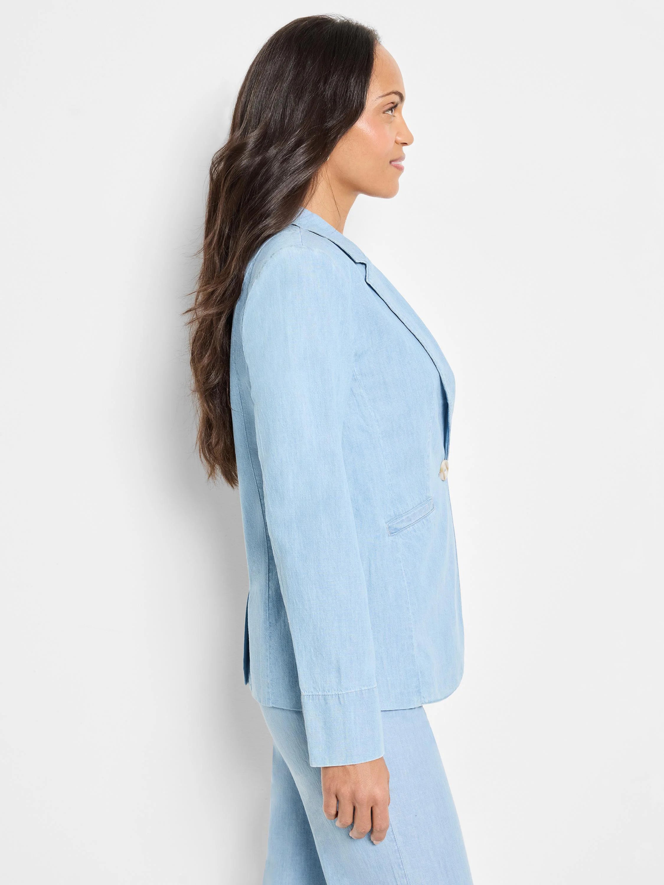 Light blue denim linen blazer, shown in profile.  Features notched lapels and buttons.