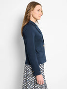 Navy blue blazer, single button, two pockets.  Model shown wearing it with a black and white patterned dress.